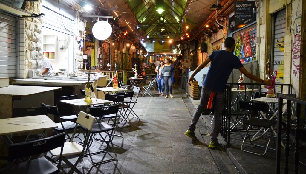 Man puts out water pipes on tables shuk, Jerusalem Israel Machane Yehuda Market