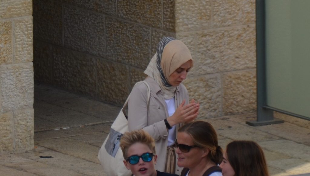 Arab girl alone in prayer in Jerusalem Israel near rest rooms