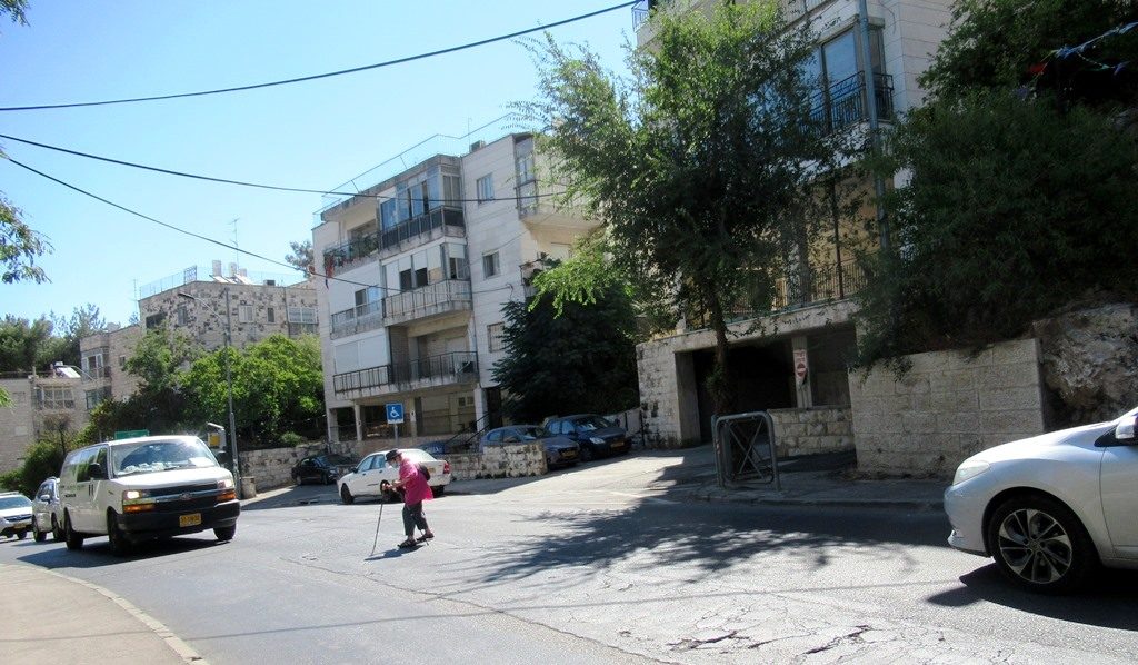 Jerusalem woman crossing street as traffic waits 